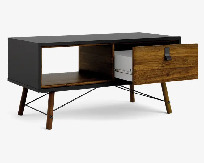 Rektangulært møbel med mat sort ydre og detaljer i naturtræ. Det har skråtstillede træben og to opbevaringsrum: én åben hylde og ét lukket skab med en trædør med synlig åretegning og sort metalhåndtag. Skabsdøren er vist åben og afslører et indvendigt opbevaringsrum, der er velegnet til elektronik eller andre genstande.