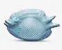 En gennemsigtig, lyseblå glasskål formet som en fisk med et tekstureret skælmønster på kroppen, hævet hale og detaljeret ansigt med indtrykt øje. Skålen har en blank overflade og en let buet form, velegnet til servering eller dekoration.
