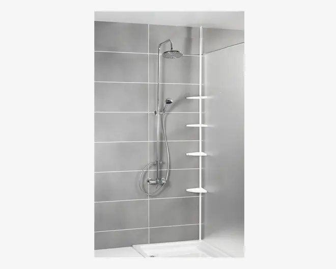 Moderne bruseopsætning med et regnbruserhoved og en håndbruser, begge i kromfinish og monteret på en lodret stang. Bruseområdet har store, lysegrå fliser med hvide fuger. Der er fire hvide hjørnehylder til opbevaring, og en klar glasvæg adskiller bruseområdet fra resten af badeværelset.