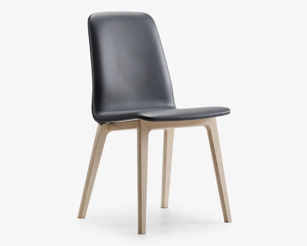 Stol med et slankt, moderne design med sort polstret sæde og ryglæn med diskrete syninger. Benene er lavet af lyst træ og vinklet udad for stabilitet og stil. Ryglænet er let buet for ergonomisk støtte.