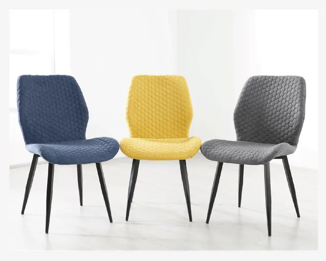 Tre moderne stole med slanke, sorte metalben og quiltet polstring. Polstringen har et bikubemønster og fås i tre farver: marineblå, sennepsgul og koksgrå. Stolene har let buede rygge og sæder for ergonomisk komfort.