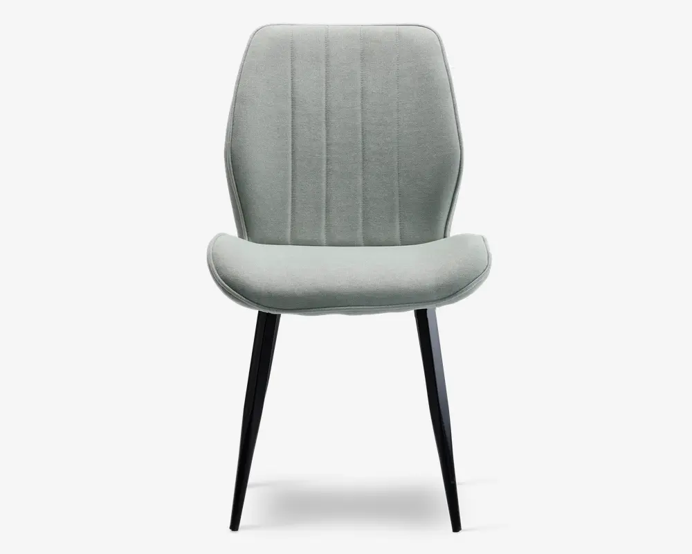 Stol med lysegråt polstret sæde og ryglæn, der har lodrette syninger for ekstra struktur. Sædet er let buet for komfort, og stolen står på fire slanke, sorte metalben, der er let skråtstillede for stabilitet og et moderne udtryk.