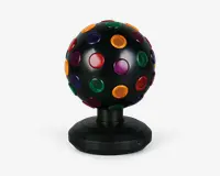 Sort kugleformet enhed med mat overflade, udstyret med flere runde, gennemsigtige linser i rød, grøn, gul, lilla og blå, jævnt fordelt over hele overfladen. Kuglen er monteret på en solid, facetslebet sort fod med en lille tænd/sluk-knap og er designet til at rotere og projicere farverige lys, når den er i brug.