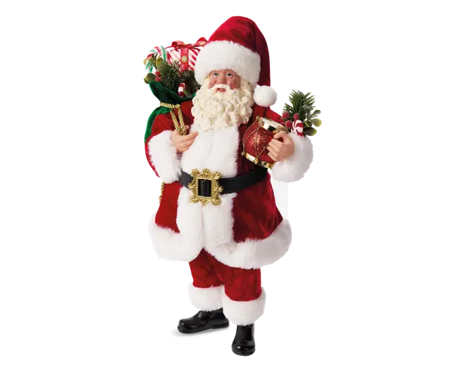 Figur iført traditionelt rødt og hvidt julemandskostume med blød pelskant på jakke, bukser og hue. Figuren har et sort bælte med stort guldfarvet spænde, sorte støvler og krøllet hvidt skæg. I den ene hånd holder den en grøn sæk fyldt med julegrønt, slikstokke og gaver. I den anden hånd bærer den en rød gaveæske pyntet med guldbånd og kunstige grangrene. Udseendet er festligt og detaljeret, velegnet som julepynt.
