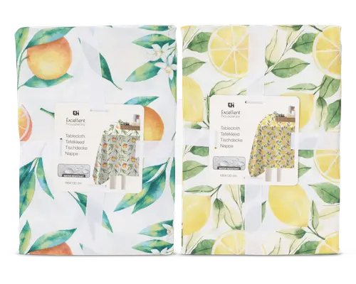 To sammenfoldede stofgenstande med farverige frugt-motiver. Den til venstre har appelsiner og grønne blade på hvid baggrund, samt små hvide blomster. Den til højre viser gule citroner, citronskiver og grønne blade, også på hvid baggrund. Begge er pænt pakket ind med et hvidt bånd og et produktmærke, der viser et eksempel på det fulde design.