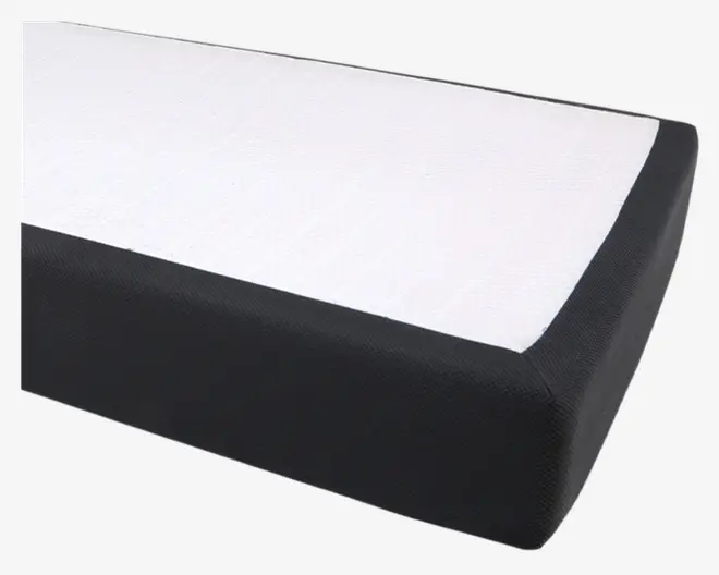 Rektangulært produkt med en tyk, sort stofkant og en hvid, tekstureret overflade på toppen. Kanterne er afrundede, og designet fremstår moderne og minimalistisk.