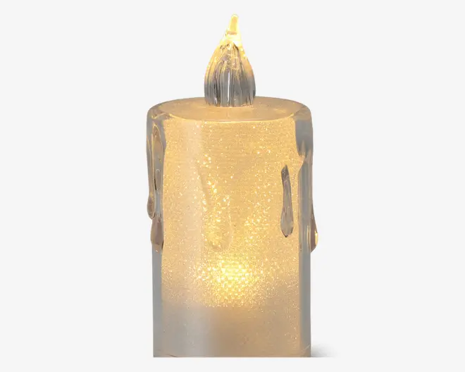 Cylinderformet LED-lys med en frostet, halvgennemsigtig overflade og en varm gul glød. Lyset har realistiske voksdråber ned ad siderne og en flammeformet top, der udsender lys og efterligner udseendet af et ægte stearinlys.