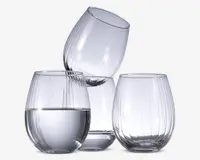 Sæt med tre klare, stilkfri glas med rund form og lodret rillet tekstur. Ét glas er delvist fyldt med vand, mens de to andre er tomme. Glassene har et moderne, elegant design og en solid bund for stabilitet.