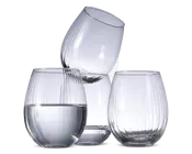 Sæt med tre klare, stilkfri glas med rund form og lodret rillet tekstur. Ét glas er delvist fyldt med vand, mens de to andre er tomme. Glassene har et moderne, elegant design og en solid bund for stabilitet.