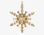 Guldfarvet ornament formet som en snefnug, dekoreret med flere facetslebne, dråbeformede og runde klare krystaller, der er arrangeret symmetrisk. Krystallerne sidder i en ramme af guldfarvet metal, hvilket giver et funklende og elegant udtryk. Øverst er der en lille løkke til ophængning.