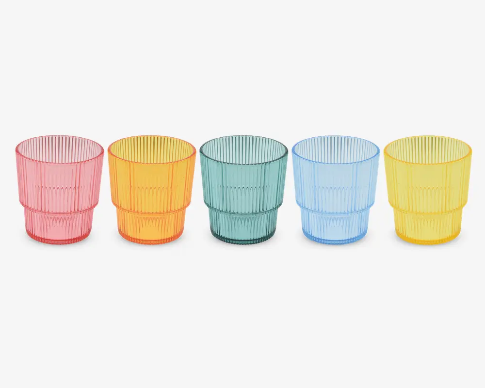 Sæt med fem stabelbare drikkeglas i gennemsigtig plast, hver med en forskellig farve: pink, orange, grøn, blå og gul. Glassene har en rillet overflade med lodrette linjer og en let udadbuet kant. Hvert glas er lavt og bredt, designet til nem stabling og godt greb.