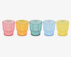 Sæt med fem stabelbare drikkeglas i gennemsigtig plast, hver med en forskellig farve: pink, orange, grøn, blå og gul. Glassene har en rillet overflade med lodrette linjer og en let udadbuet kant. Hvert glas er lavt og bredt, designet til nem stabling og godt greb.