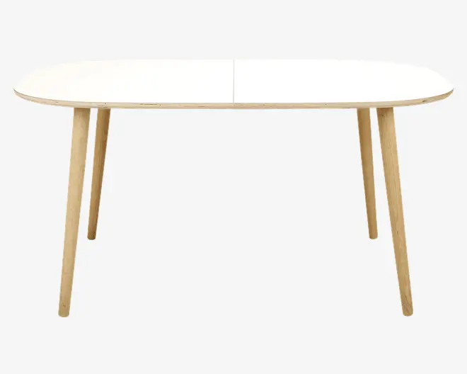 Rektangulært bord med afrundede hjørner, glat hvid bordplade og fire skråtstillede ben i lyst træ. Bordet har et minimalistisk, moderne design med rene linjer og en tynd bordplade.