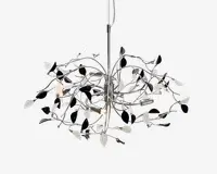 Moderne loftlampe med blank kromfinish, der har flere buede metalarme arrangeret i et grenlignende mønster. Armene er pyntet med dekorative sorte og hvide bladformede detaljer, og flere små synlige pærer er fordelt rundt i designet for at give omgivende belysning.