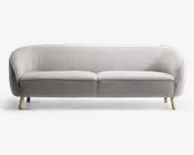 En moderne tresæders sofa med lysegråt, tekstureret stofbetræk. Sofaen har en let buet ryg og armlæn, der giver en hyggelig og omsluttende form. Den har to sædehynder og står på fire korte, skråtstillede træben i naturfarve, hvilket giver et skandinavisk inspireret udtryk.