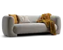 Lysegrå sofa med polstrede, afrundede armlæn og lav ryg, stylet med to pyntepuder i sennepsgul og beige striber samt et kraftigt sennepsgult tæppe lagt over højre side.