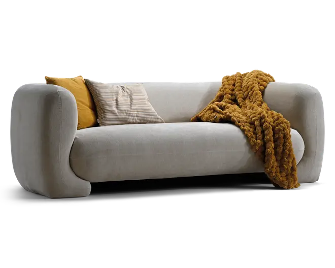 Lysegrå sofa med polstrede, afrundede armlæn og lav ryg, stylet med to pyntepuder i sennepsgul og beige striber samt et kraftigt sennepsgult tæppe lagt over højre side.