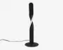 Høj, moderne lampe med sort mat finish og et unikt snoet design. Lampen har en sammenhængende LED-lysbånd, der snor sig rundt om den centrale søjle og giver et elegant og nutidigt udtryk. Den står på en rund, flad fod for stabilitet og har en synlig ledning, der går ud fra bunden.
