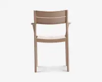 En minimalistisk stol med en glat, mat beige overflade. Ryglænet har to vandrette lameller for støtte, og sædet er let buet for komfort. Stolen har lige ben og integrerede armlæn, hvilket giver et moderne og funktionelt udtryk.