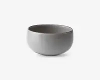 En rund, glat keramikskål med mat lysegrå yderside og en lidt mørkere inderside. Skålen har et minimalistisk design med blødt buede sider og en bred åbning, velegnet til servering af supper, salater eller snacks.