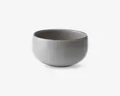 En rund, glat keramikskål med mat lysegrå yderside og en lidt mørkere inderside. Skålen har et minimalistisk design med blødt buede sider og en bred åbning, velegnet til servering af supper, salater eller snacks.