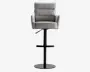 En moderne barstol med polstret sæde, ryglæn og armlæn betrukket med lysegråt stof. Ryglænet har vandrette syninger for ekstra komfort og stil. Stolen har en sort metalbase med cirkulær fodstøtte og rund sokkel, samt en håndtag til justerbar højde.