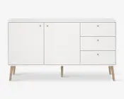 Et moderne skænk med et minimalistisk design og mat hvid finish. Den har to store skabslåger til venstre og tre skuffer til højre, alle med små runde guldfarvede greb. Skænken står på fire skråtstillede træben, hvilket giver den et retro udtryk.