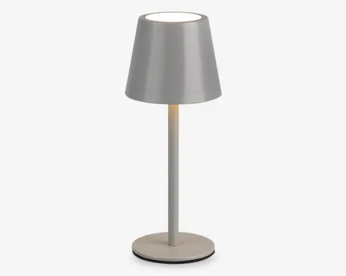 Elegant, moderne bordlampe med mat lysegrå finish. Lampen har en konisk lampeskærm, en slank cylindrisk stang og en rund, flad fod for stabilitet. Lyset udsendes fra åbningen i toppen, hvilket giver et blødt, fokuseret skær. Minimalistisk design, der passer til nutidige indretninger.