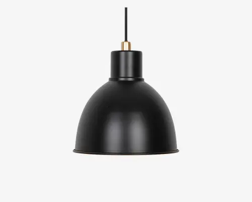 Mat sort pendellampe i sort med en kuppelformet metalskærm. Lampen har en glat, buet overflade og et minimalistisk design med en lille messingdetalje øverst, hvor ledningen er fastgjort. Lampens inderside er ikke synlig, men det samlede udtryk er moderne og industrielt.