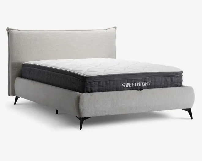 En moderne seng med en lysegrå polstret ramme og hovedgærde, udstyret med en tyk, blød madras med quiltet hvid top og mørkegrå sider. Madrassen har et synligt mærkelogo 'SWEETNIGHT' på siden og ser ud til at have et ekstra komfortlag øverst. Sengen står på korte, skrå sorte ben, hvilket giver et moderne udtryk.