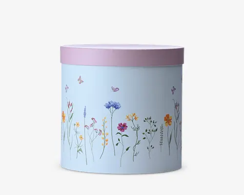 En cylindrisk lyseblå beholder med et blødt rosa låg, dekoreret med fine vilde blomster og små sommerfugle langs siderne.