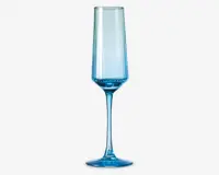 Høj, slank glas med blå nuance, lang stilk og smal, facetslebet skål. Glasset har et moderne, geometrisk design med lodrette linjer langs skålen og en solid, rund fod for stabilitet.