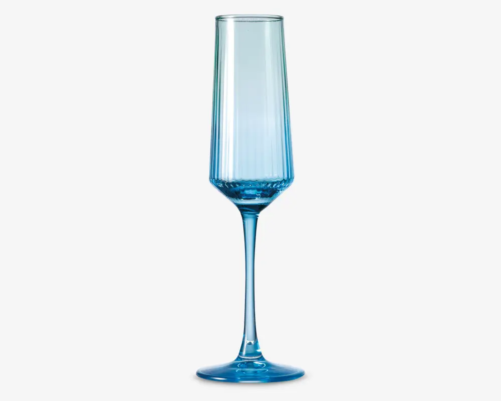 Høj, slank glas med blå nuance, lang stilk og smal, facetslebet skål. Glasset har et moderne, geometrisk design med lodrette linjer langs skålen og en solid, rund fod for stabilitet.