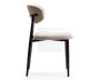 Sidebillede af en stol med polstret sæde og ryglæn betrukket med et tekstureret, lysebeige stof. Stolen har et minimalistisk design med slanke, sorte metalben og en let skrånende rygstøtte for ergonomisk komfort. Ryglænet er adskilt fra sædet og forbundet med to metalstænger, hvilket giver et moderne og let udtryk.