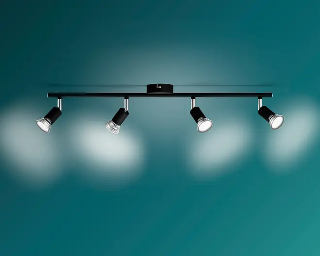 Elegant sort loftlampe med fire justerbare spothoveder monteret på en lige, vandret skinne.