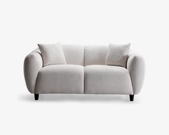Moderne to-personers sofa med blødt, tekstureret lysebeige stofbetræk. Sofaen har afrundede, polstrede armlæn og ryglæn for ekstra komfort. Inkluderer to matchende, firkantede puder. Sofaen står på korte, mørke træben, hvilket giver et moderne og indbydende udtryk.