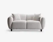 Moderne to-personers sofa med blødt, tekstureret lysebeige stofbetræk. Sofaen har afrundede, polstrede armlæn og ryglæn for ekstra komfort. Inkluderer to matchende, firkantede puder. Sofaen står på korte, mørke træben, hvilket giver et moderne og indbydende udtryk.