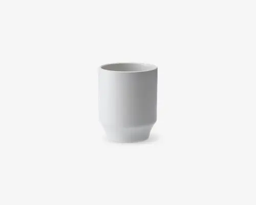 En minimalistisk, cylindrisk hvid kop med en glat mat overflade. Koppen har lige sider og en lidt tykkere bund, hvilket giver den et moderne og rent udtryk. Der er ingen hank eller dekorative elementer, hvilket understreger det enkle og funktionelle design.
