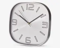 Et moderne vægur med afrundet firkantet form og sølvfarvet ramme. Urskiven er hvid med store, stiliserede sorte tal ved 12, 3, 6 og 9, samt enkle sorte streger ved de øvrige timer. Uret har tre visere: en sort timeviser, en sort minutviser og en tynd sort sekundviser. Designet er minimalistisk og let at aflæse.