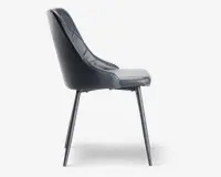 Sidevisning af en moderne stol med sort kunstlæderbetræk og diskrete syninger. Stolen har et let buet ryglæn for ergonomisk støtte og en polstret siddeflade for komfort. Den står på fire slanke, skråtstillede metalben med mat sort finish, hvilket giver et stilrent og minimalistisk udtryk.