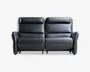 En moderne to-personers sofa betrukket med glat sort læder. Sofaen har bløde, polstrede ryglæn og sædehynder for ekstra komfort. Armlænene er let buede og polstrede, hvilket giver ekstra støtte. Sofaen har et enkelt, minimalistisk design med synlige syninger langs kanterne, hvilket giver et moderne udtryk. Basen er lav, og den samlede konstruktion fremstår solid og velpolstret.