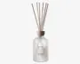 Frostet glasflaske med trælåg, der indeholder flere naturfarvede duftpinde. Flasken har minimalistisk sort tekst på forsiden, herunder ordene 'SOFT LINEN.' Det samlede design er enkelt og elegant, velegnet til moderne boligindretning.