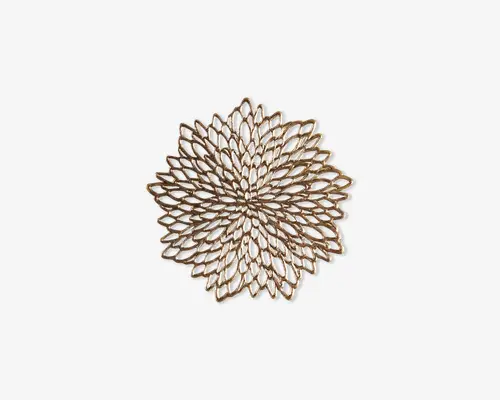 Indviklet designet metaltrivet med et blomstret, kronbladslignende mønster. Trivetten har en symmetrisk, gennembrudt struktur med overlappende ovale former, der stråler ud fra midten og giver et elegant og dekorativt udtryk. Den metalliske finish tilføjer et strejf af raffinement, hvilket gør den velegnet til både funktionel og dekorativ brug.